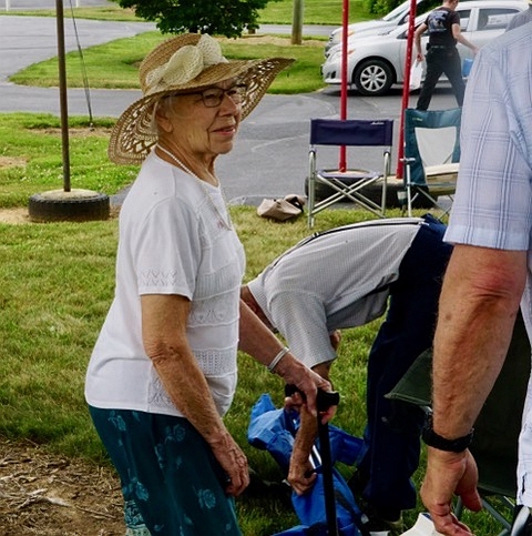a senior, Irene, displays her large sun hat